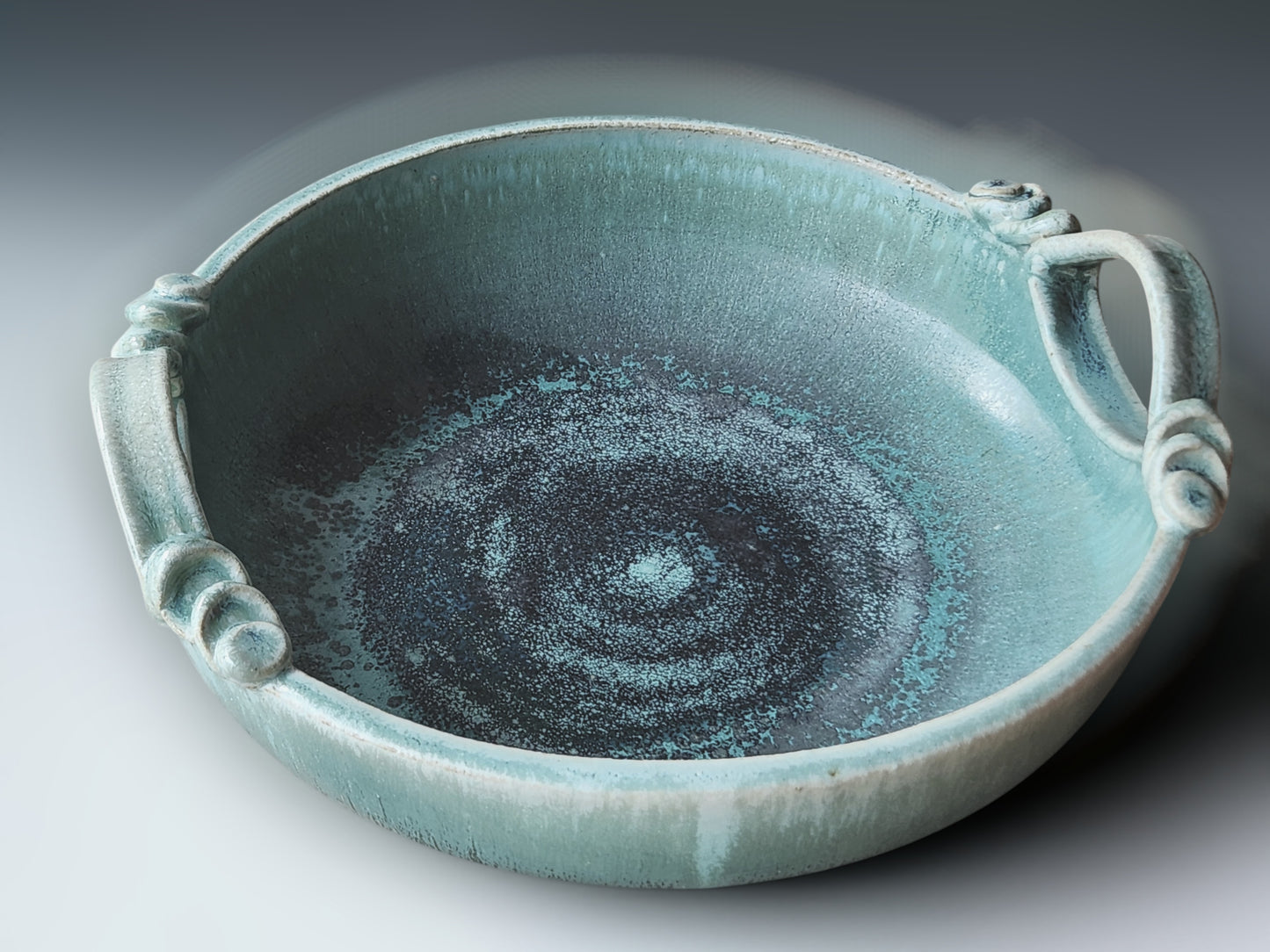 Contemporary pottery serving bowl with soft aqua glaze and handcrafted decorative handles