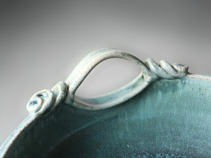 Detailed glaze close-up of handcrafted pottery bowl highlighting speckled aqua surface texture