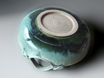 Handcrafted shallow ceramic bowl with looped handles and ocean-inspired glaze detailing