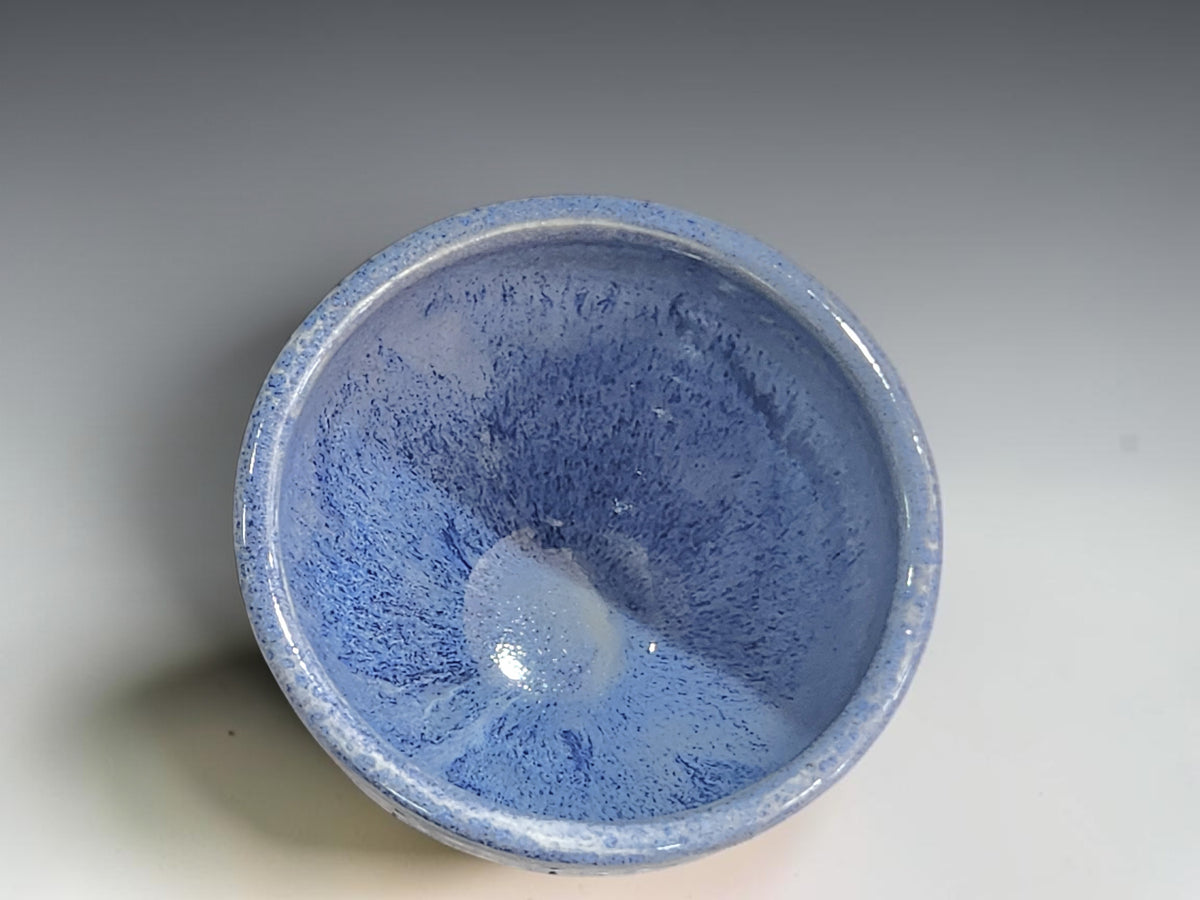 Empty blue ceramic bowl showing its glazed interior and softly rounded rim.