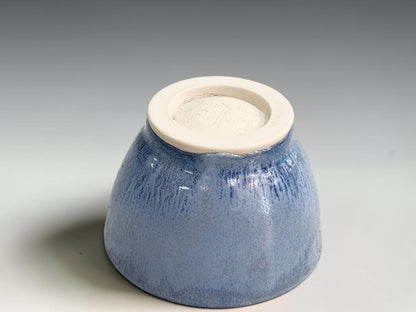 Small blue condiment bowl with deep curved sides and an unglazed cream base.