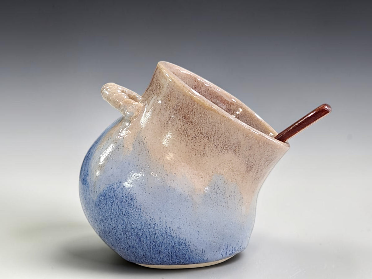 Brown and blue ceramic salt keeper with wooden spoon
