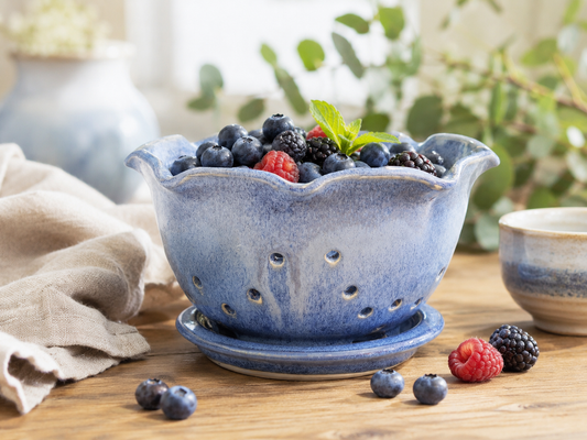Glossy blue pottery berry bowl with blueberries and raspberries