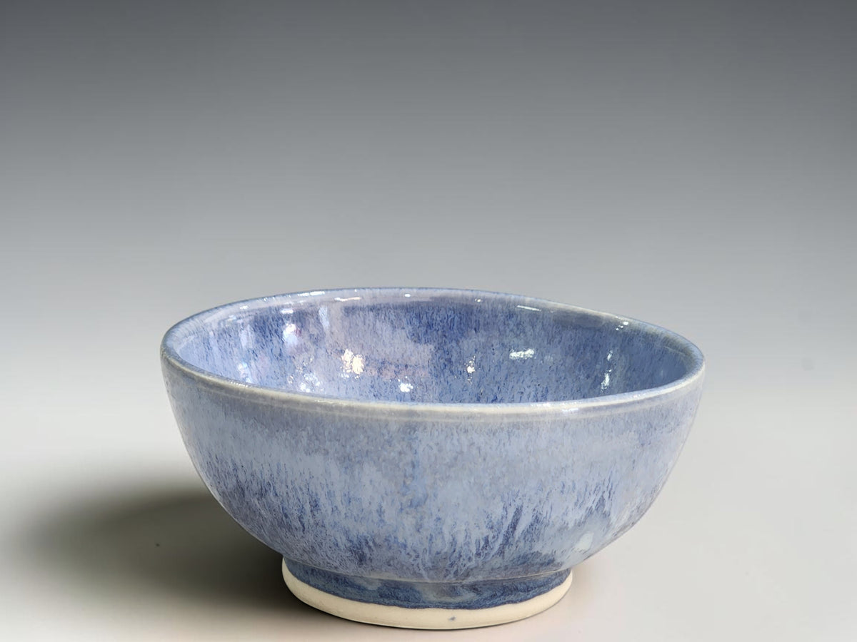 Handmade blue ceramic bowl by Buxton Pottery with flowing mottled glaze.