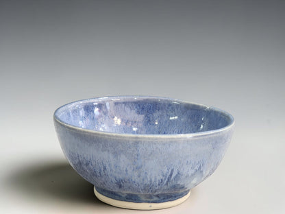 Handmade blue ceramic bowl by Buxton Pottery with flowing mottled glaze.