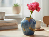 a handmade porcelain bud vase with blue and gold glaze