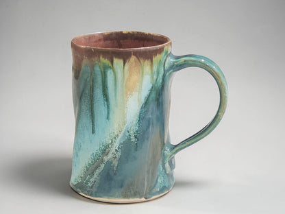 Tall handmade stoneware mug with comfortable handle in turquoise and earthy brown glaze