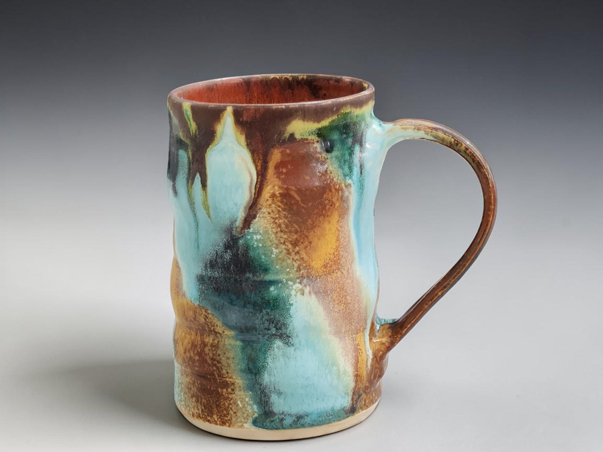 Handmade stoneware mug with flowing turquoise, rust and green glaze, crafted by Buxton Pottery in Melbourne Australia