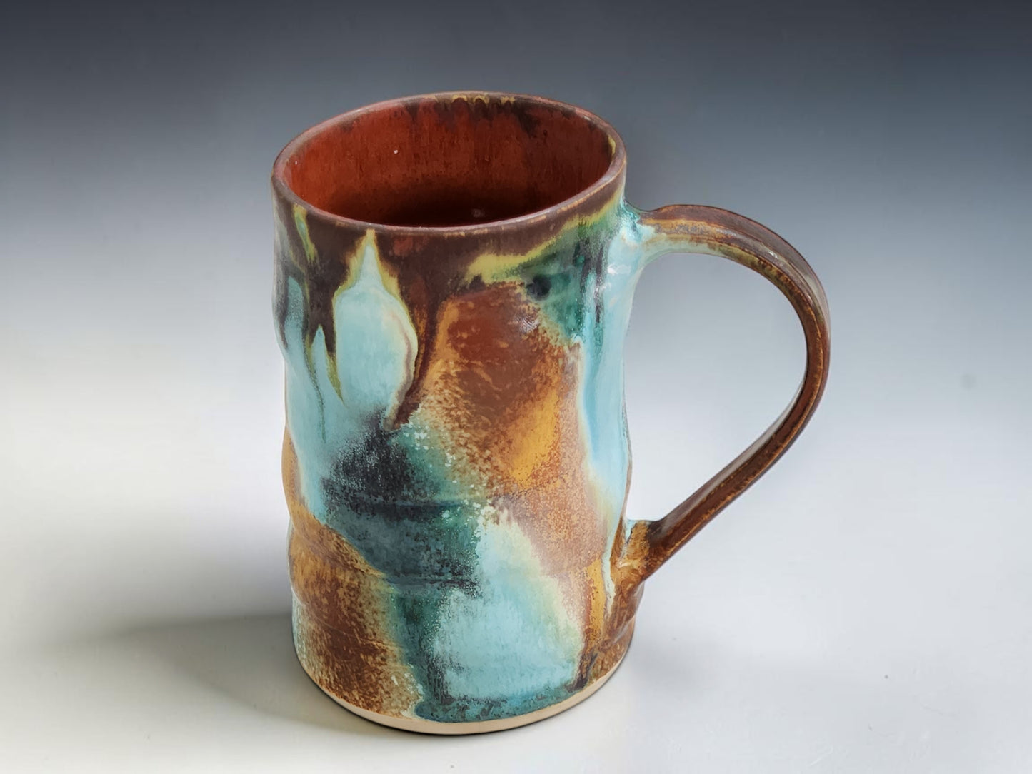 Bush Creek Collection handmade ceramic mug with rich terracotta interior and layered blue green glaze