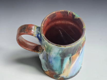 Top view of Bush Creek handmade pottery mug showing its colourful flowing glaze pattern.