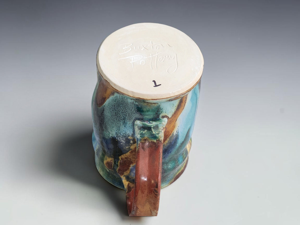 Buxton Pottery Bush Creek mug with turquoise glaze and warm earthy accents.