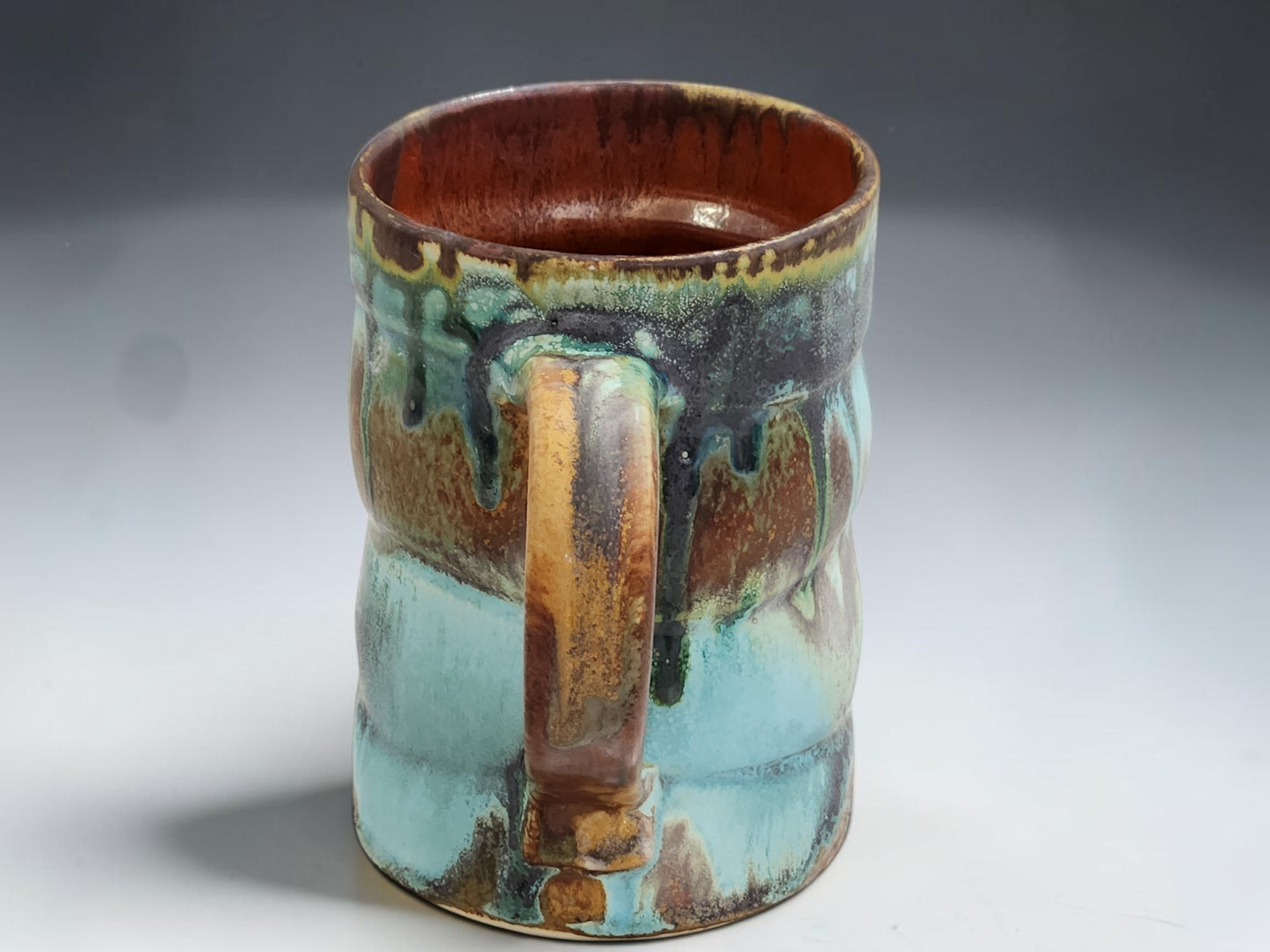 Buxton Pottery handmade mug with red brown interior and layered Bush Creek exterior glaze