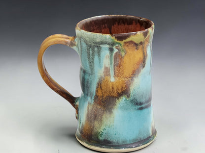 Australian handmade pottery mug with rustic turquoise, brown and rust glaze movement