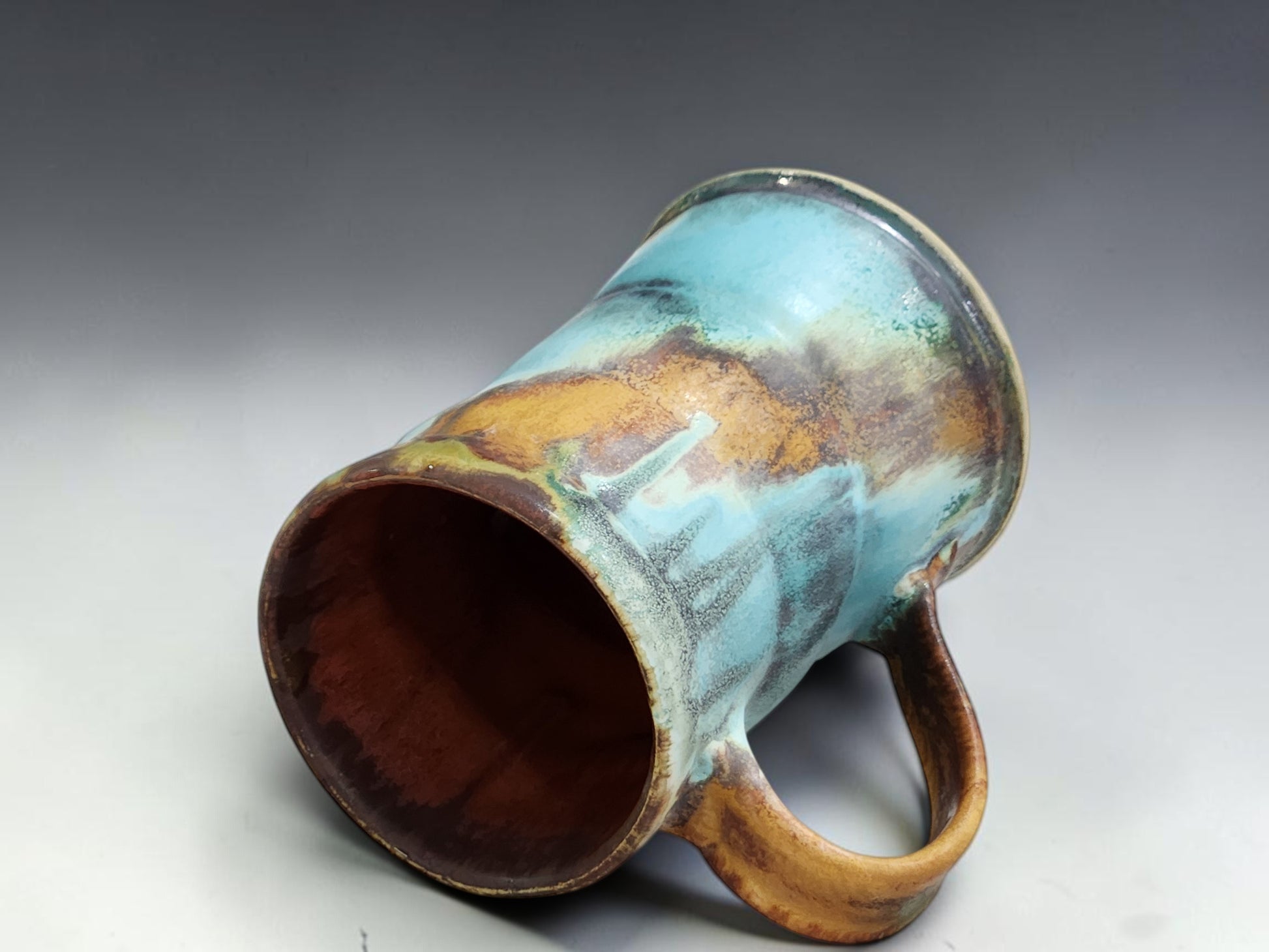 Buxton Pottery handmade mug with red brown interior and layered Bush Creek exterior glaze