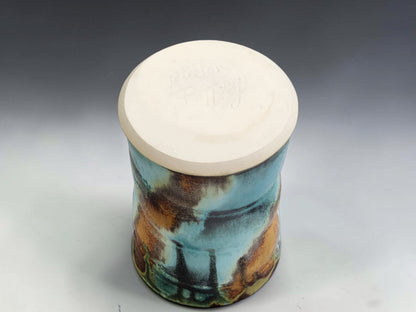 Handmade pottery mug on grey studio background showing handle, glaze movement and red brown lining