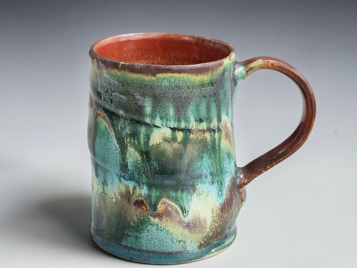Handmade 400ml pottery mug with flowing turquoise, forest green and earthy brown glaze.