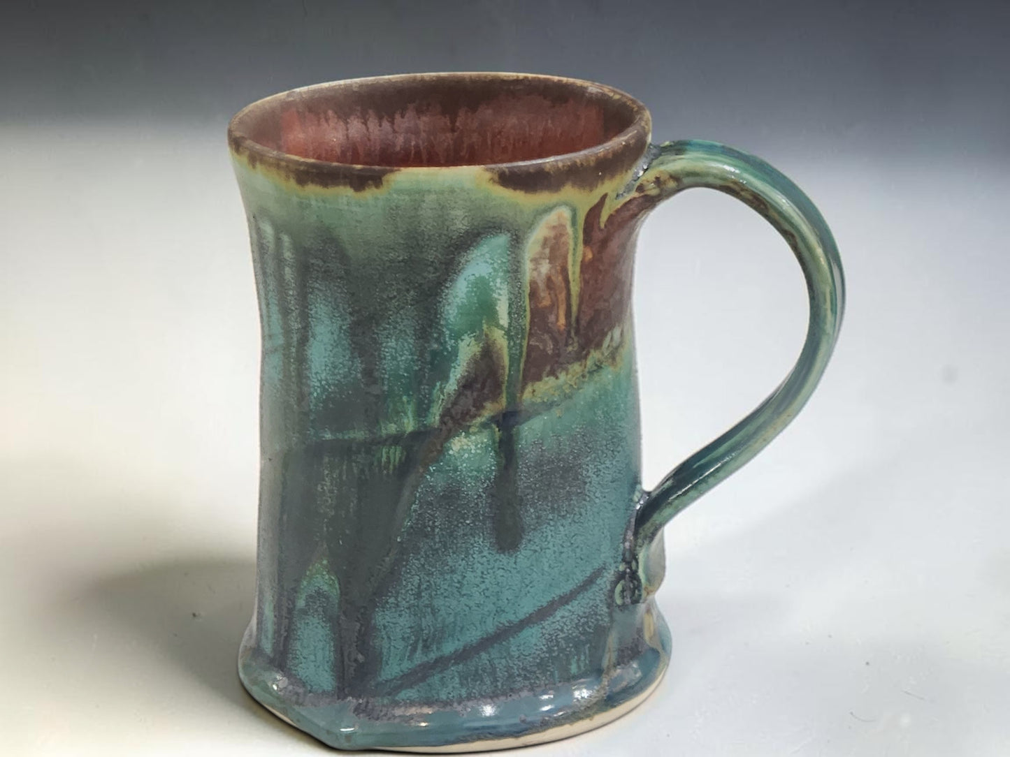 Australian handmade ceramic coffee mug with cascading turquoise and earthy brown glaze, handcrafted in Melbourne.