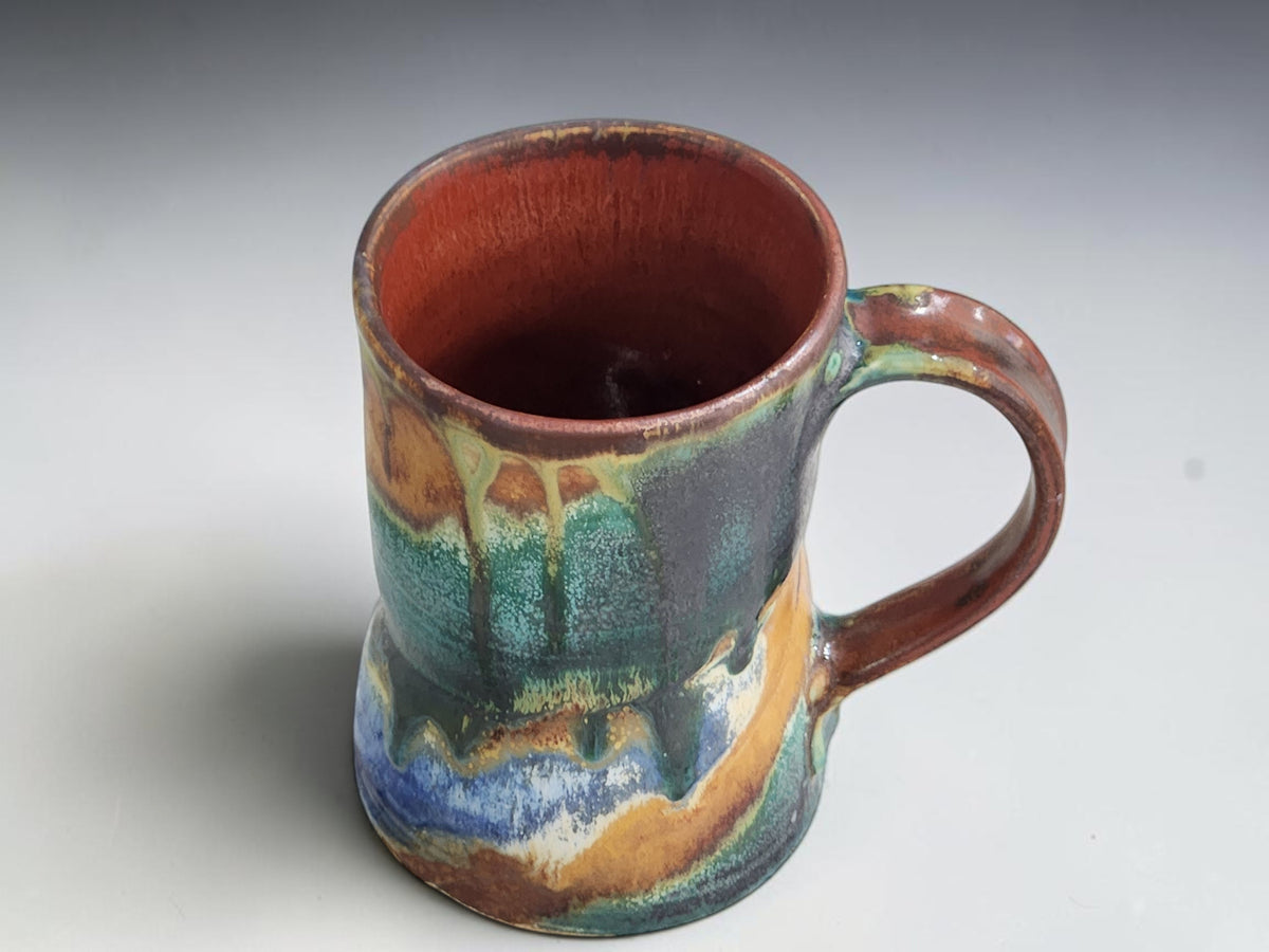 Front view of a Bush Creek mug showing turquoise glaze and a pale cream band.