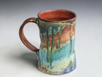side view of layered green, brown and blue glaze details on a handmade mug.