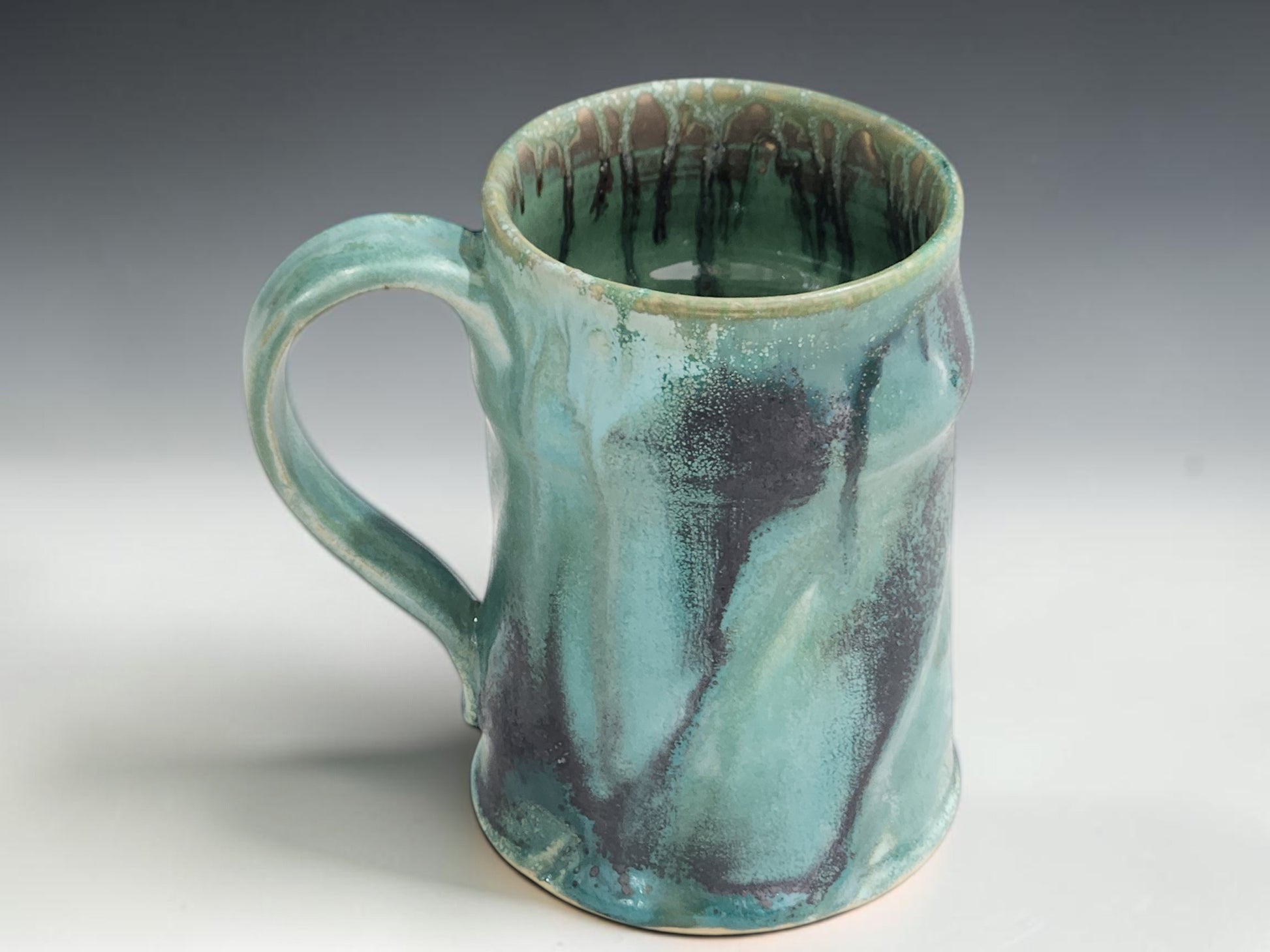 Large handmade ceramic coffee mug with soft green glaze and organic handmade shape