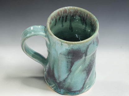 Wheel-thrown pottery mug with 350ml capacity, curved handle and glossy turquoise glaze on grey studio background