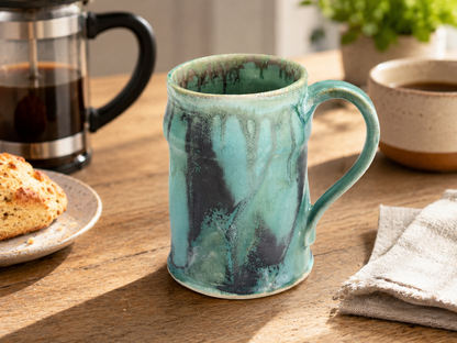 Handmade ceramic 350ml mug in soft turquoise green glaze styled with French coffee press and pastry in a warm kitchen setting