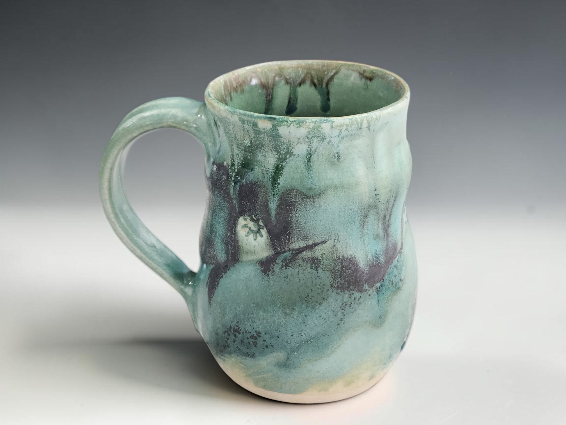 Large handmade ceramic coffee mug with soft green glaze and organic handmade shape