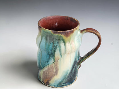 Tall handmade mug with gently curved sides and a large brown handle.