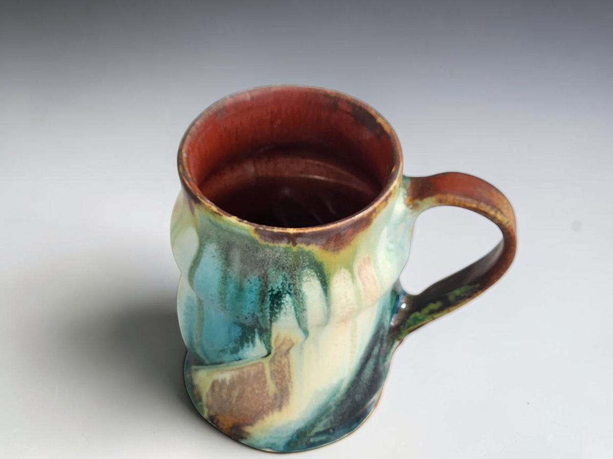 Top view of mottled turquoise and dark green glaze on a Bush Creek mug.