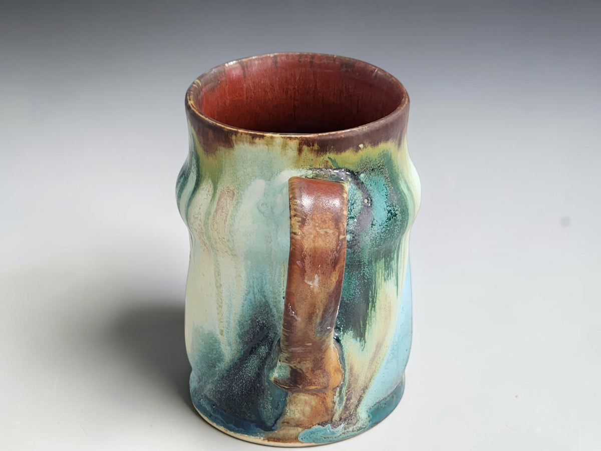 Buxton Pottery 400ml mug with soft cream, blue-green and ochre brown accents.