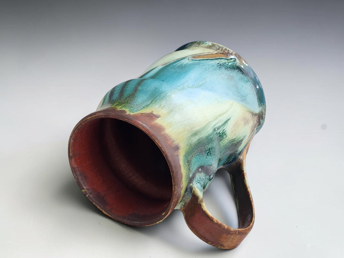 Handmade pottery mug measuring 12cm tall and 8cm across the base.