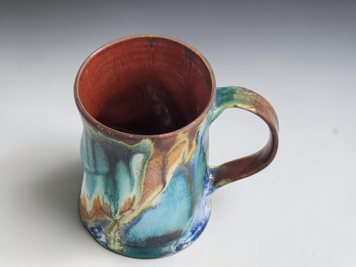 Bush Creek pottery mug with a curved brown handle and rust-brown glazed interior