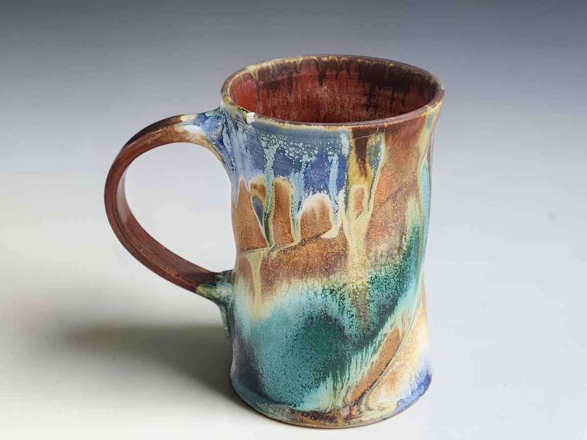 Side view of a Bush Creek mug showing forest green glaze over warm brown patches.