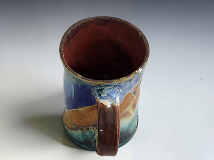Blue and cream ceramic mug with a gently flared rim and subtly waisted shape.