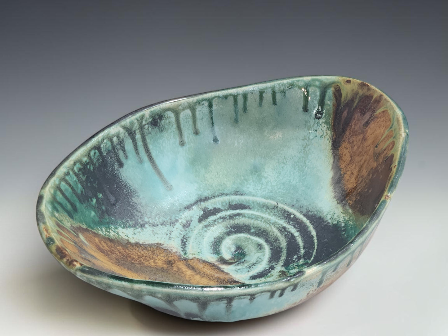Handmade pottery serving bowl with organic oval shape and sculptural altered form