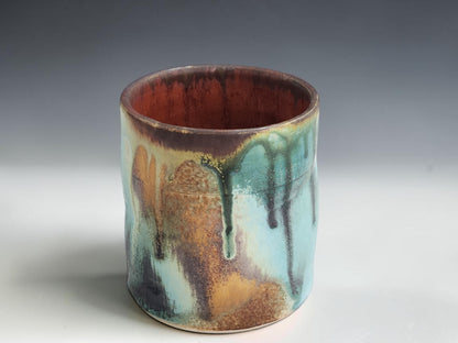 Handmade stoneware tumbler with straight-sided shape and rich organic glaze movement