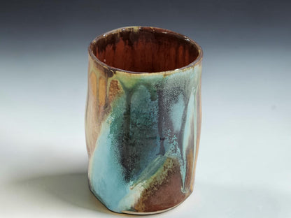 Handmade ceramic cup with glossy layered glaze and natural handmade surface variation