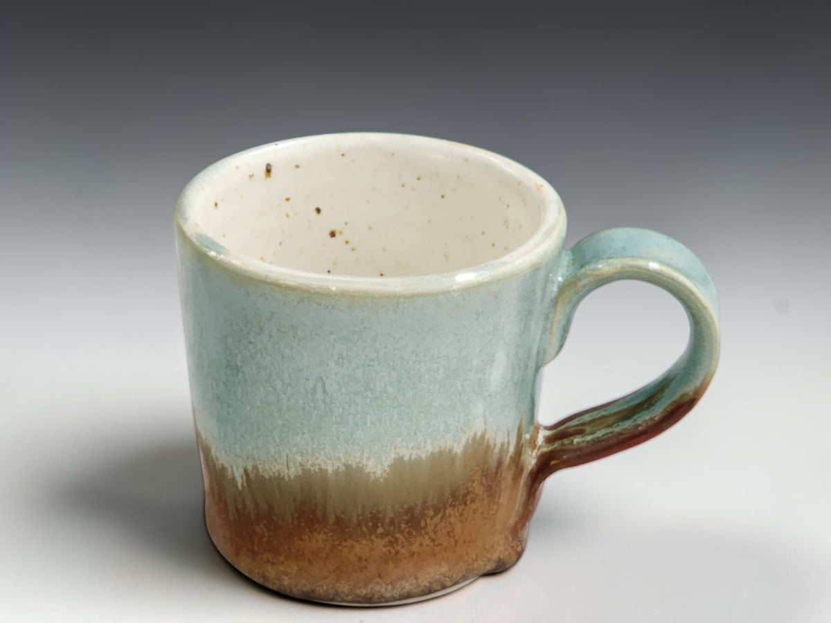 One-finger handle on spearmint and red-brown espresso cup