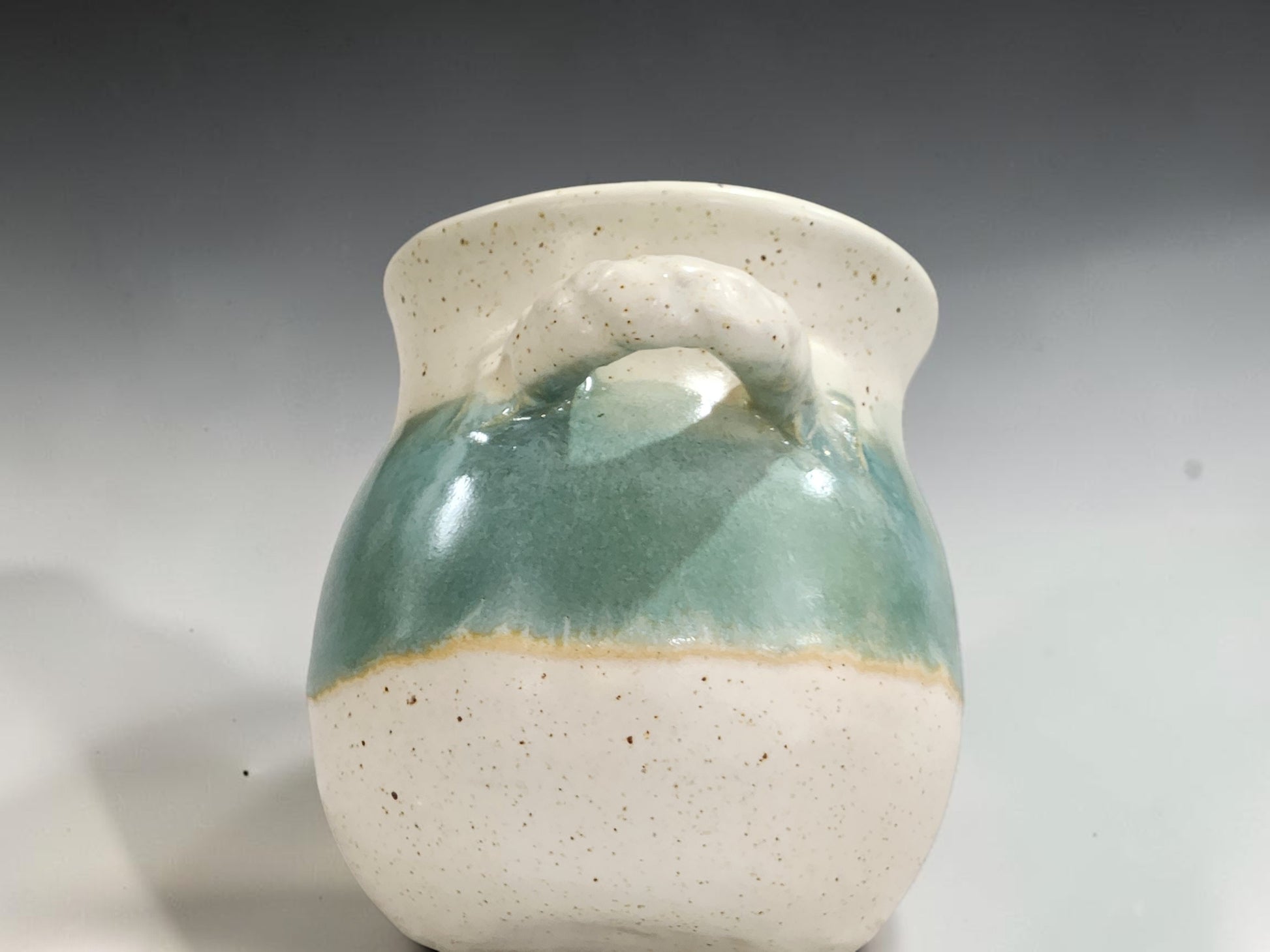 Small pottery salt keeper with wide opening and curved handle