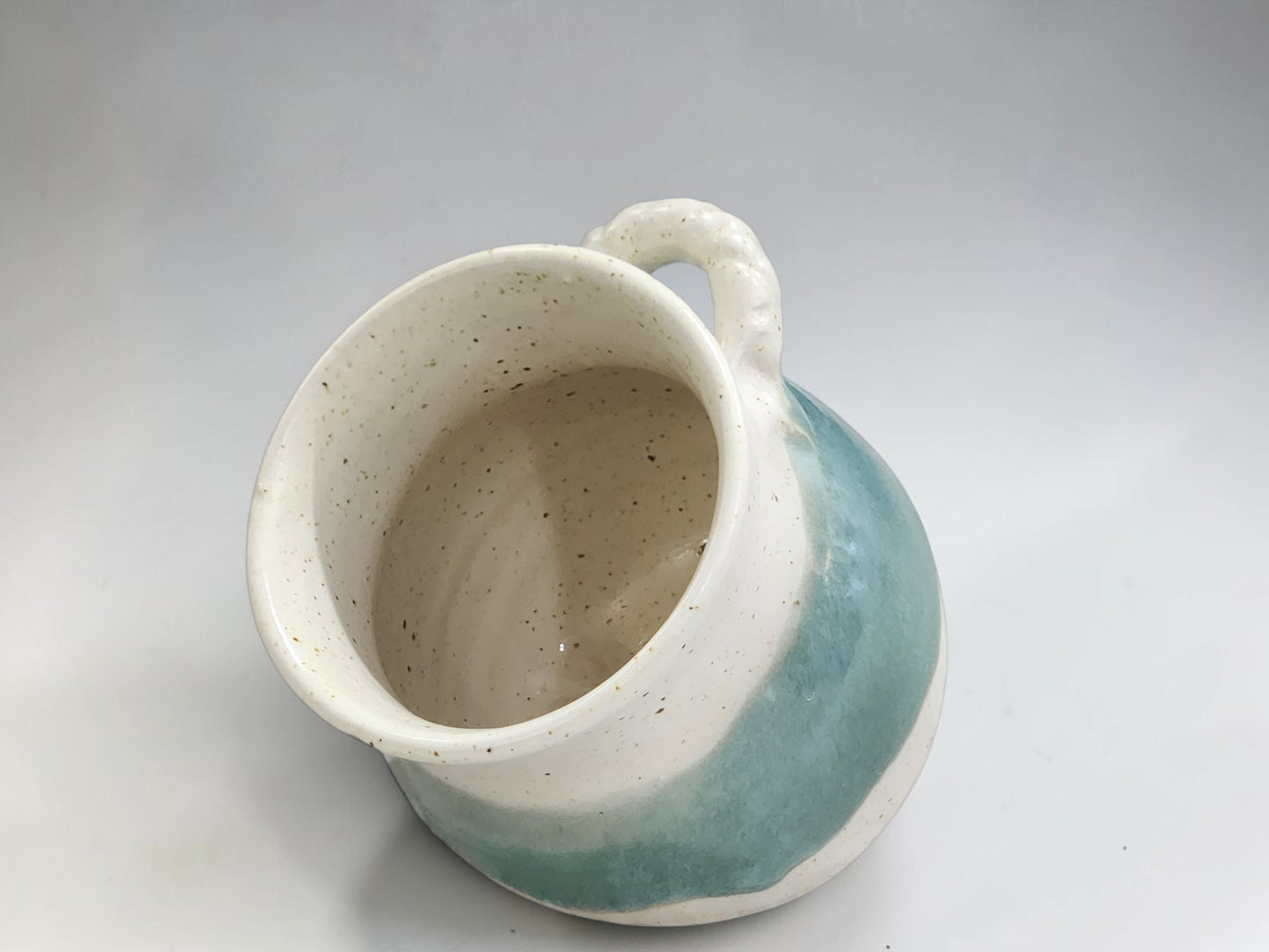 Small handmade salt container with speckled glaze and spoon rest opening