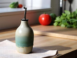 Handmade ceramic oil bottle with speckle cream and green glaze