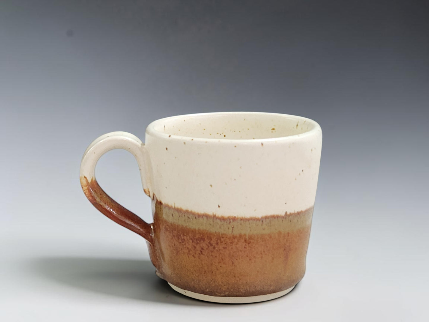 Handmade espresso cup in speckled buttermilk and red-orange glaze