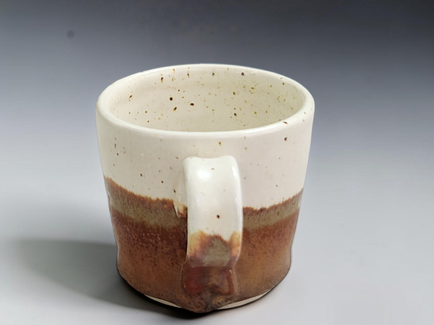 Handmade ceramic espresso cup showing natural glaze variation