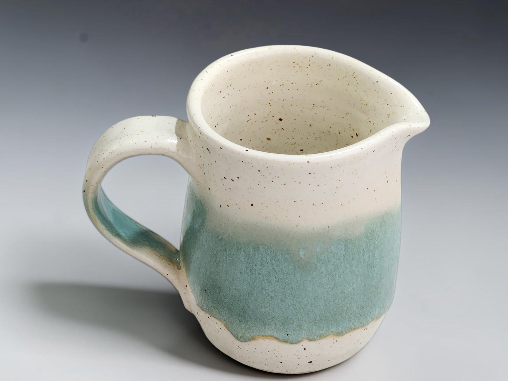 Small wheel-thrown stoneware milk jug with hand-shaped pouring lip