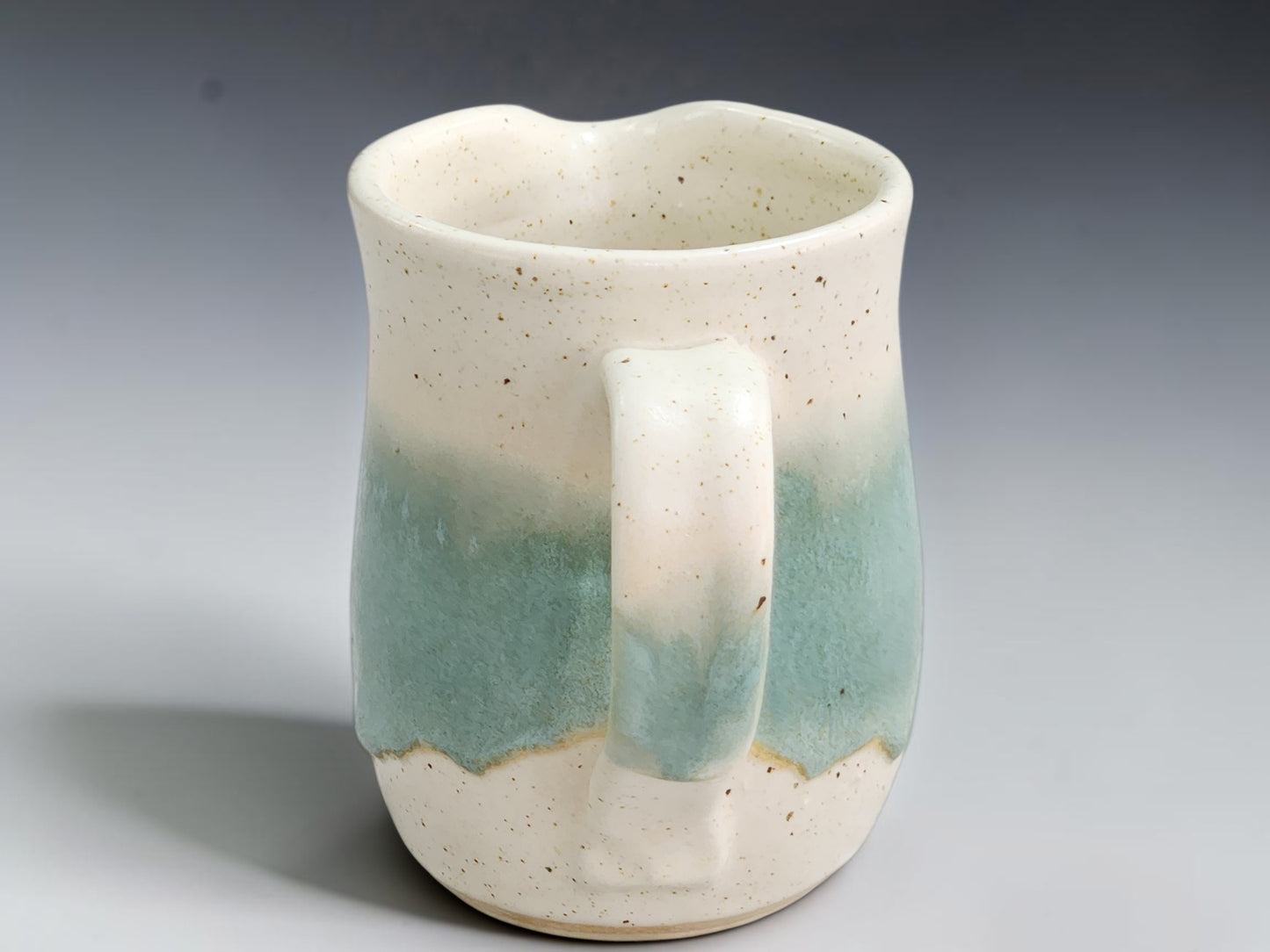 Side view of spearmint pottery jug showing its compact curved handle