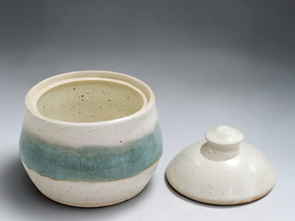 Handmade pottery lidded sugar bowl with natural speckled glaze and soft green detail