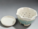 Cream and green glazed ceramic colander bowl with drainage holes