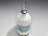 Handmade pottery oil dispenser in cream and pale green tones