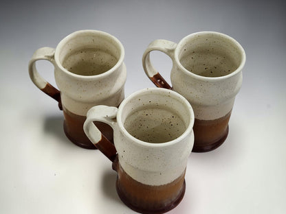 Three handmade ceramic beer steins with rustic cream and earthy brown finish
