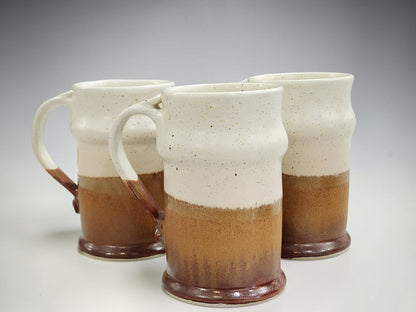 Group of handmade stoneware beer steins in neutral cream and brown tones
